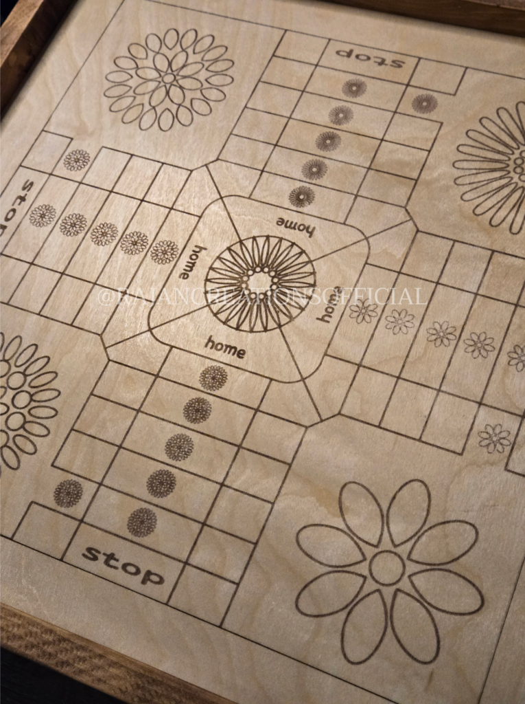 Close up image shot of engraved, wooden ludo board game with wood-stained borders and geometric flower design.