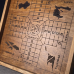 Close up image shot of engraved, wooden ludo board game with wood-stained borders and Caribbean island (e.g., Haiti, Jamaica, Trinidad & Guyana) design.